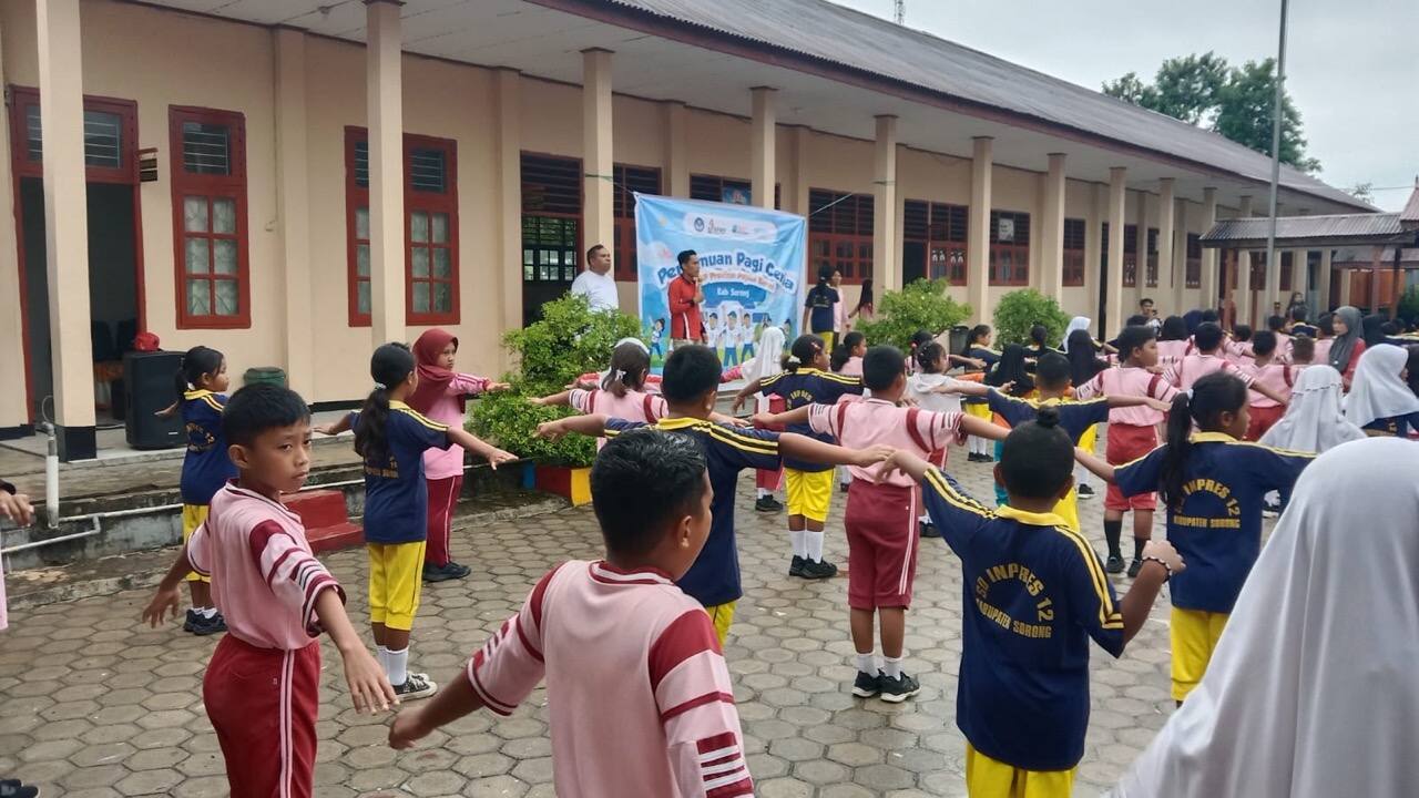 Anak-anak berseragam olahraga melakukan senam di halaman sekolah